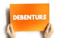 Debenture is a type of long-term business debt not secured by any collateral, text concept on card