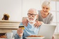 Loving couple of pensioners checking their debit card number