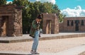 DEBOD TEMPLE, MADRID. SPAIN - JUNE 10, 2018. Young stylish woman with bun casual hairstyle admiring the iconic egyptian monument Royalty Free Stock Photo