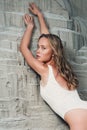 Blonde girl sitting at sandy beach. Outdoor portrait of pretty curly woman. beauty retouch Royalty Free Stock Photo