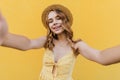 Debonair european woman in hat making selfie with happy smile. Fascinating girl with wavy hairstyle