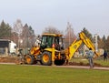 Debowiec/Poland - March 27, 2018: Spring cleaning of green territory in the city. Tractor and excavator for upgrading the green pl Royalty Free Stock Photo