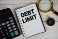 Debt Limit text with calculator, magnifying glass and compass on wooden background Royalty Free Stock Photo