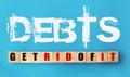 DEBTS - get rid of it on sky blue background on wooden cubes. Financial concept Royalty Free Stock Photo