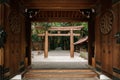 Meiji Jingu Shrine wooden Torii seen through old gate entrance - Tokyo Royalty Free Stock Photo