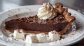 Decadent chocolate tart with whipped cream on a white plate