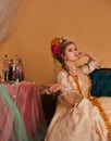 Decadent rococo woman dressed in period fashion holding empty champagne glass
