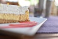 Decadent slice of cake on a white plate with a red drizzle of syrup