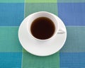 Decaffeinated black tea in a cup on a place mat.