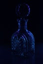 Decanter on a black background shining the blue