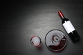 Decanter, glass and bottle with red wine on dark background, flat lay. Royalty Free Stock Photo