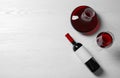 Decanter, glass and bottle with red wine on wooden background