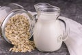 Decanter with oat milk on a gray background. Organic vegetarian product.