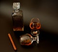 Decanter and two glasses with cognac and a Cuban cigar on a black background