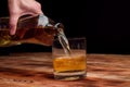 From a decanter, whiskey is poured into a glass