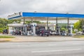 View of an urban convenience store with cars and people