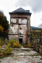 Decayed house in an autumn landscape, metaphor for old age poverty or life evening without pension insurance