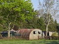 A decaying Nissan Hut stands by several Garden Sheds in a garden near Gardyne Village in Angus.