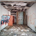 Decaying room and graffiti covered walls inside an abandoned building.