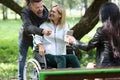 Deceased woman in wheelchair with her friends having fun while walking in park. Royalty Free Stock Photo