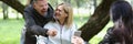 Deceased woman in wheelchair with her friends having fun while walking in park. Royalty Free Stock Photo