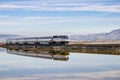 December 6, 2016, Alviso, San Jose, California, USA - Amtrak train passes through Alviso marsh on a sunny day