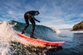 December 28, 2019. Anapa, Russia. Surfer in wetsuit on longboard with sea wave. Winter surfing in Russia