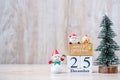 25 December calendar with Christmas decoration, snowman, Santa claus and pine tree  on wooden table background, preparation for Royalty Free Stock Photo