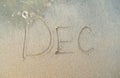 December or Dec word on beach sand.