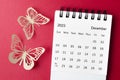 A December 2023 desk calendar for the organizer to plan and reminder with paer butterfly on red background