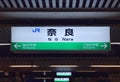 2018 December 08. Nara Japan. Japanese kanji and English Nara word train station signboard at night time