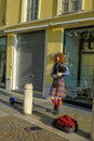 December 2020 Parma, Italy: Guy with red curly hair wearing kilt  playing bagpipes on the city street  and earning money. Street m Royalty Free Stock Photo