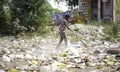 December, 2022, Raipur, India: Man sweeping the trash with broom and polyhthene big garbage area, Man cleaning the polluted area, Royalty Free Stock Photo