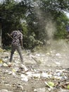 December, 2022, Raipur, India: Man sweeping the trash with broom and polyhthene big garbage area, Man cleaning the polluted area, Royalty Free Stock Photo