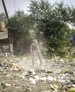 December, 2022, Raipur, India: Man sweeping the trash with broom and polyhthene big garbage area, Man cleaning the polluted area, Royalty Free Stock Photo