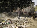 December, 2022, Raipur, India: Man sweeping the trash with broom and polyhthene big garbage area, Man cleaning the polluted area, Royalty Free Stock Photo