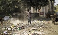 December, 2022, Raipur, India: Man sweeping the trash with broom and polyhthene big garbage area, Man cleaning the polluted area, Royalty Free Stock Photo