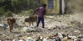 December, 2022, Raipur, India: Man sweeping the trash with broom and polyhthene big garbage area, Man cleaning the polluted area, Royalty Free Stock Photo