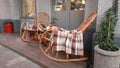 Wicker cozy armchair with blanket and small glass table outdoors. Plaid lies on the wicker furniture from rattan. Royalty Free Stock Photo