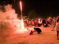 31 december 2016 sihanoukville beach cambodia, adult asian man kneeling on beach under fireworks explosion