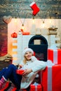 December surprise and party time. Young woman with christmas present boxes in front of christmas tree. Expressions face Royalty Free Stock Photo