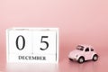 December 05th. Day 5 of month. Calendar cube on modern pink background with car