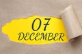 december 07. 07th day of the month, calendar date.Hole in paper with edges torn off. Yellow background is visible