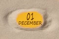 December 1. 1th day of the month, calendar date. Hole in sand. Yellow background is visible through hole