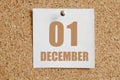 december 01. 01th day of the month, calendar date.White calendar sheet attached to brown cork board.Winter month, day of