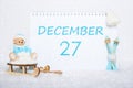 December 27th. Teddy bear sitting on a sled, blue skis and a calendar date on white snow. Day 27 of month. Royalty Free Stock Photo