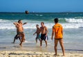 6 December 2016. Three brazilian men playing beach football in motion on the background of waves at Copacabana beach