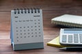 December 2023 white desk calendar on wooden table with notepad, calculator and pen background. Year end concept and copy Royalty Free Stock Photo