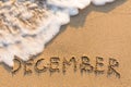 December - word drawn on the sand beach