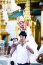 17 December 2016 young myanmar childern in traditional cloth ride the neck of his cousin walking around the shwedagon pagoda in